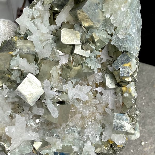 Large cluster of pyrite cubes and white quartz from Hunan, China, close-up of the crystal faces