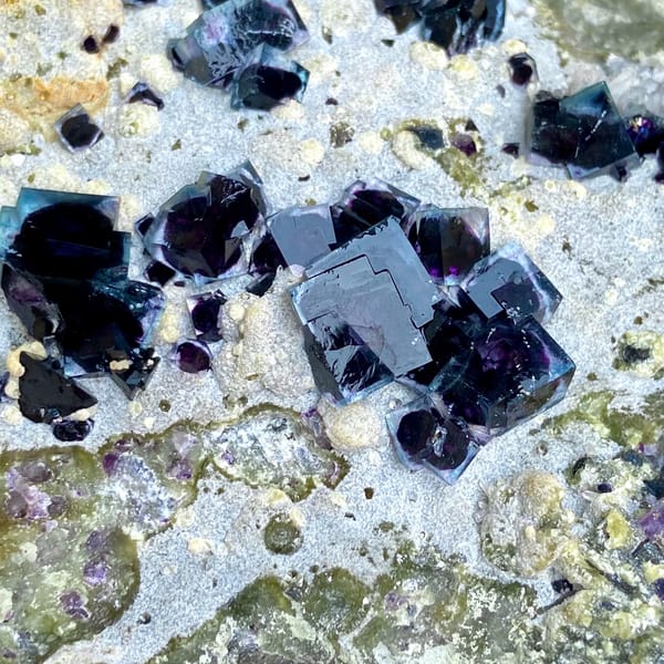 Plate of purple-cored window fluorite on stand from Inner Mongolia, China, close-up of the crystal faces