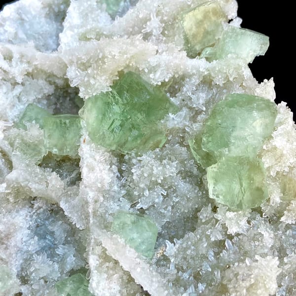 Large plate of pale green stepped fluorite over quartz from Fujian, China, close-up of the crystal faces