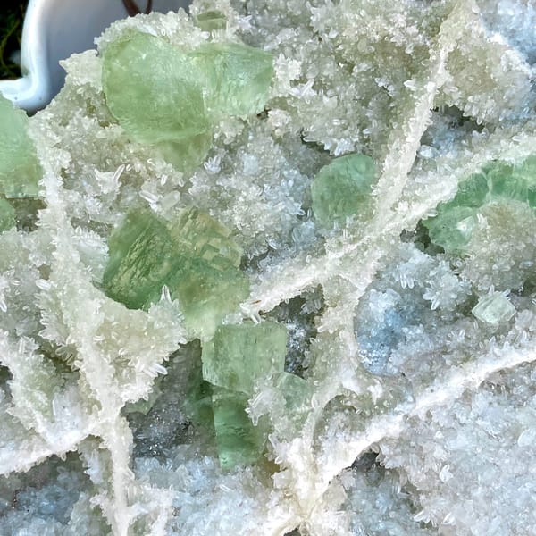 Large plate of pale green stepped fluorite over quartz from Fujian, China, detail of the matrix contact