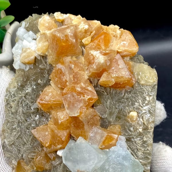 Orange scheelite crystals with pale blue fluorite on mica from Xuebaoding, Sichuan, China, side view