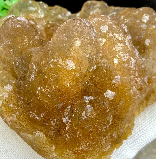 Amber pineapple fluorite of stacked translucent columns from Henan, China, detail of the matrix contact