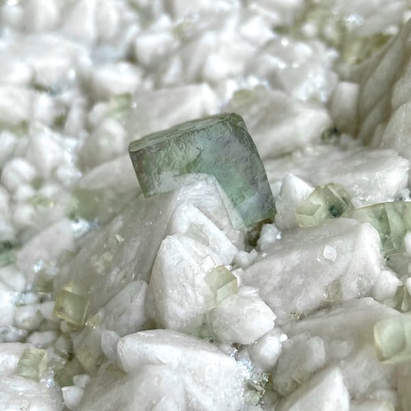 White quartz plate with pale green fluorite cubes from Inner Mongolia, China, close-up of terminations