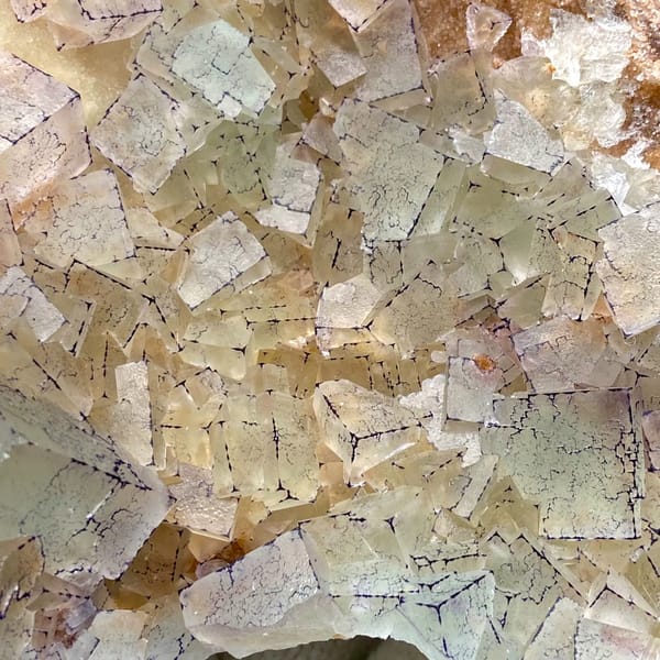 Plate of purple-edged fluorite cubes from Guizhou, China, detail of the matrix contact