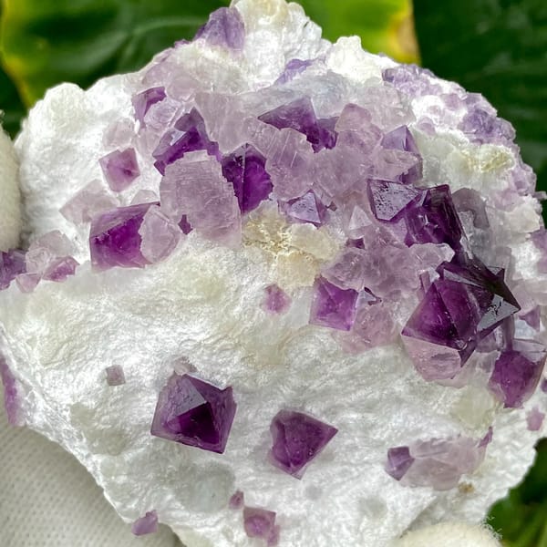 Purple-red fluorite octahedra on white recrystallised block from Zhejiang, China, close-up of the crystal faces