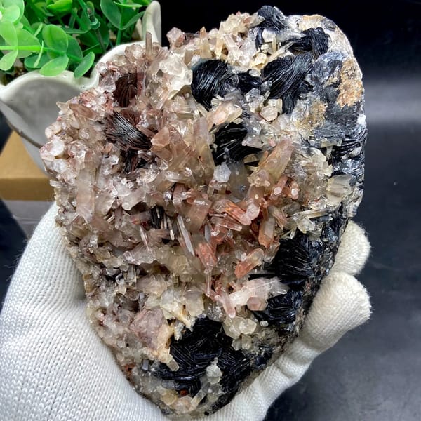 Plate of black specular hematite with pink-skinned quartz from Guangdong, China, close-up of the crystal faces