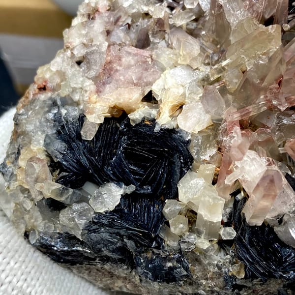 Plate of black specular hematite with pink-skinned quartz from Guangdong, China, detail of the matrix contact