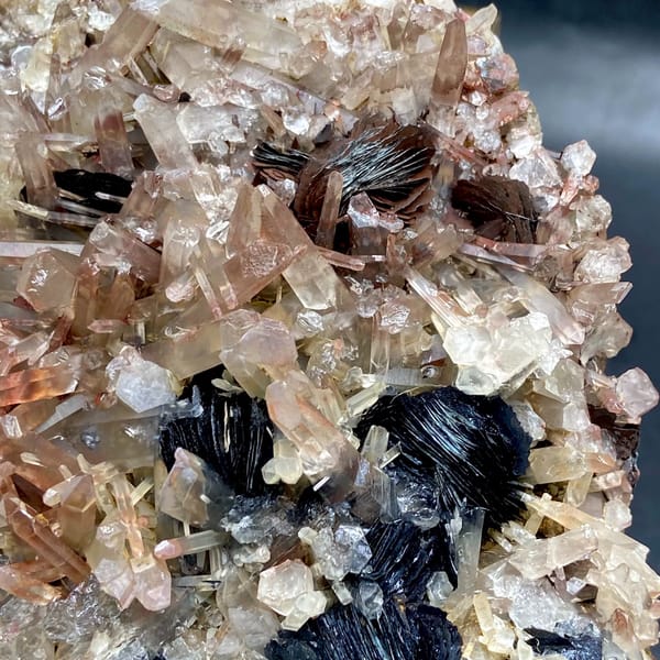 Plate of black specular hematite with pink-skinned quartz from Guangdong, China, close-up of terminations