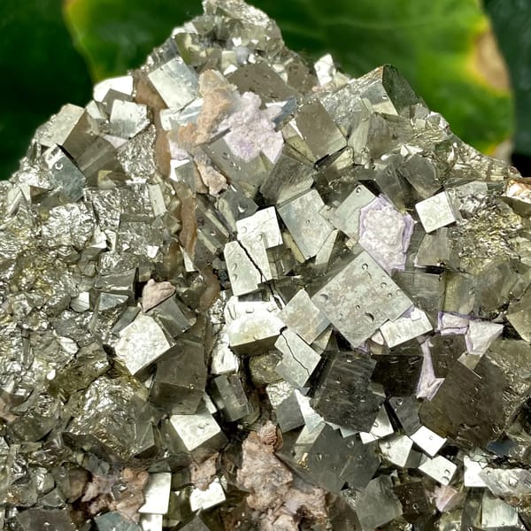 Dome of sharp brassy pyrite cubes from Shangbao, Hunan, China, detail of the matrix contact