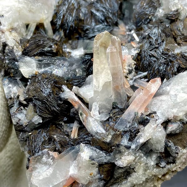 Plate of black specular hematite with quartz prisms from Guangdong, China, detail of the matrix contact