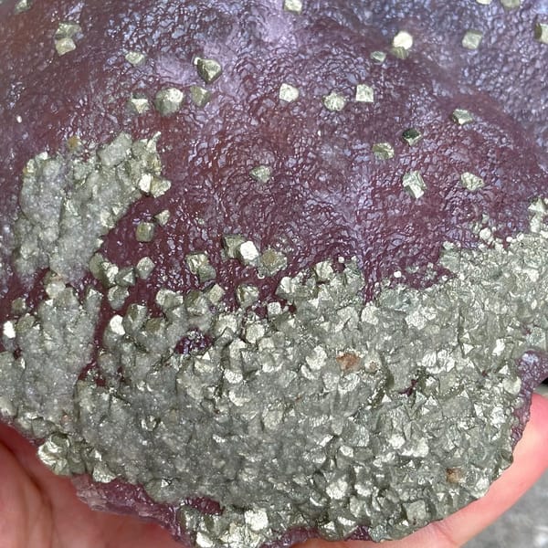 Pink-purple botryoidal fluorite dome speckled with pyrite from Jiangxi, China, side view