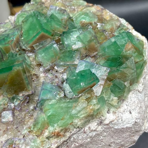 Plate of glassy green fluorite cubes with purple edges from Hebei, China, close-up of the crystal faces