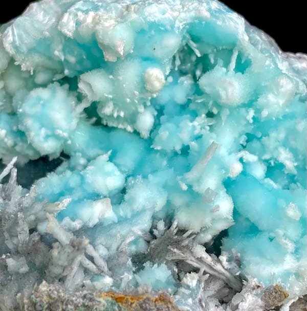Sky-blue botryoidal aragonite over white needles from Yunnan, China, close-up of the crystal faces