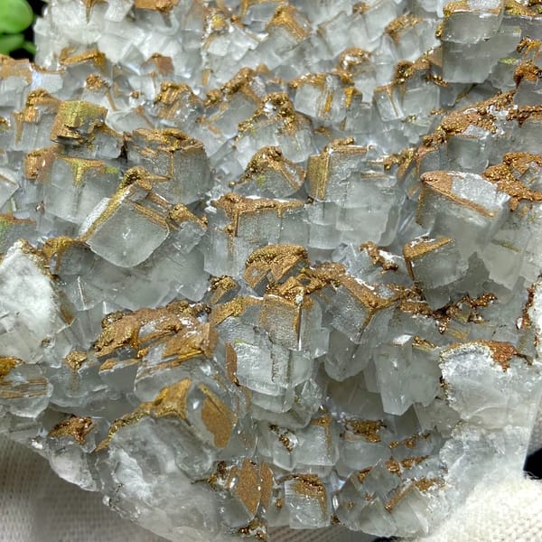 Plate of pale pyramid calcite coated in rusty iridescent pyrite from Hunan, China, detail of the matrix contact
