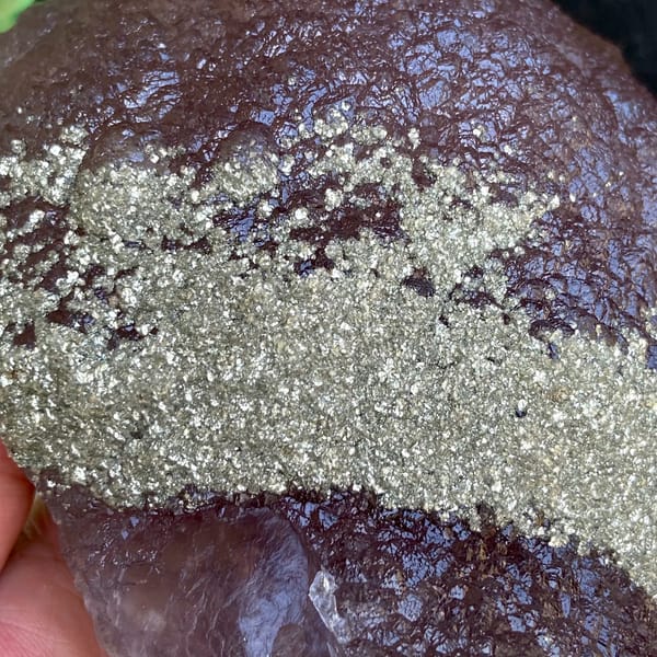 Plum-purple botryoidal fluorite ball dusted with pyrite from Jiangxi, China, close-up of the crystal faces