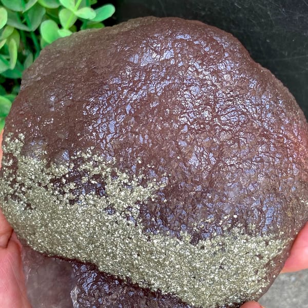 Plum-purple botryoidal fluorite ball dusted with pyrite from Jiangxi, China, side view