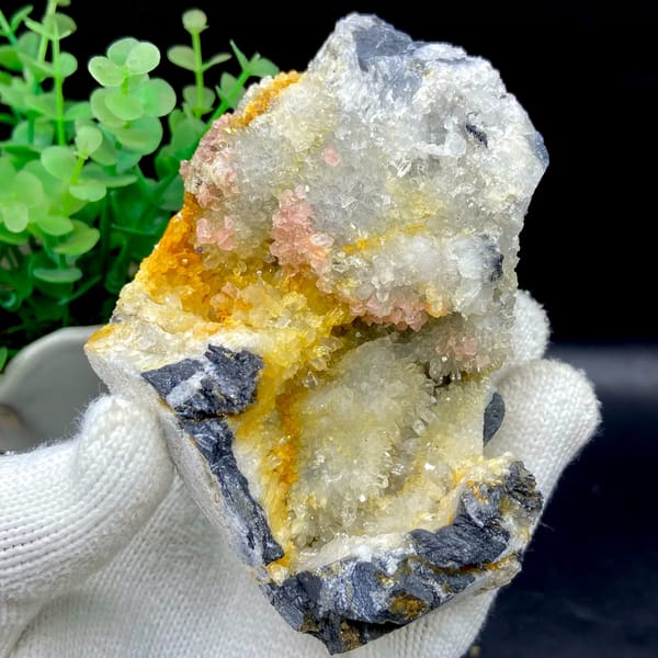 Platy rhodochrosite in quartz pocket rimmed by dark sulfide from Guangxi, China, close-up of the crystal faces