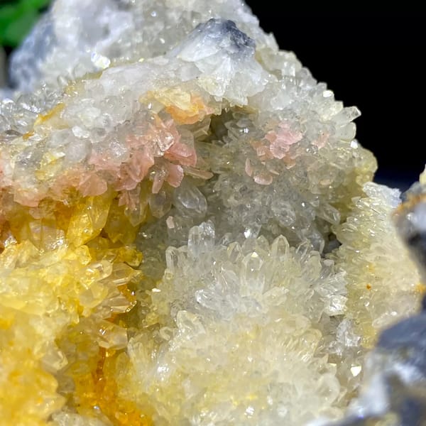 Platy rhodochrosite in quartz pocket rimmed by dark sulfide from Guangxi, China, detail of the matrix contact