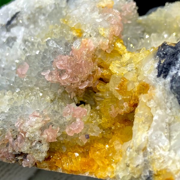 Platy rhodochrosite in quartz pocket rimmed by dark sulfide from Guangxi, China, overall view