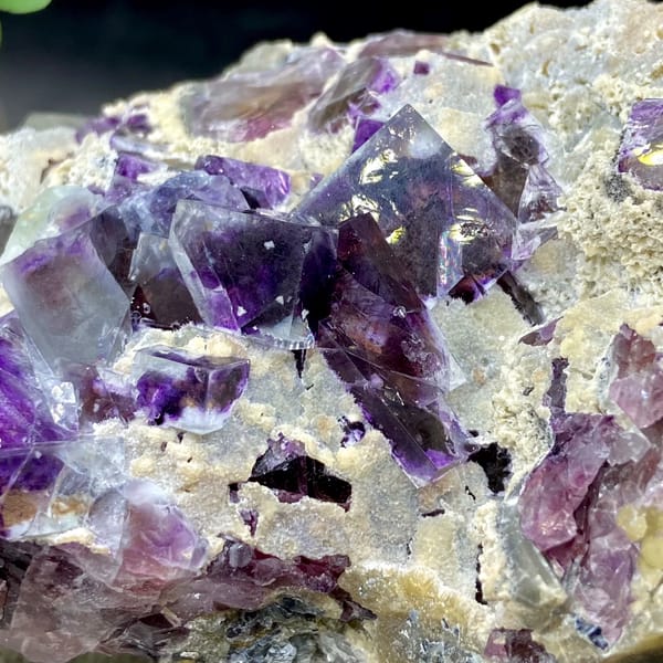 Transparent purple phantom fluorite cubes on tan matrix from Inner Mongolia, China, close-up of the crystal faces