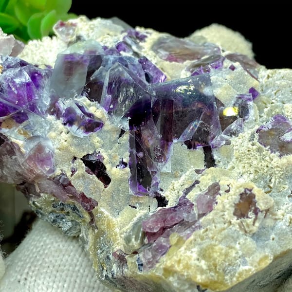 Transparent purple phantom fluorite cubes on tan matrix from Inner Mongolia, China, detail of the matrix contact