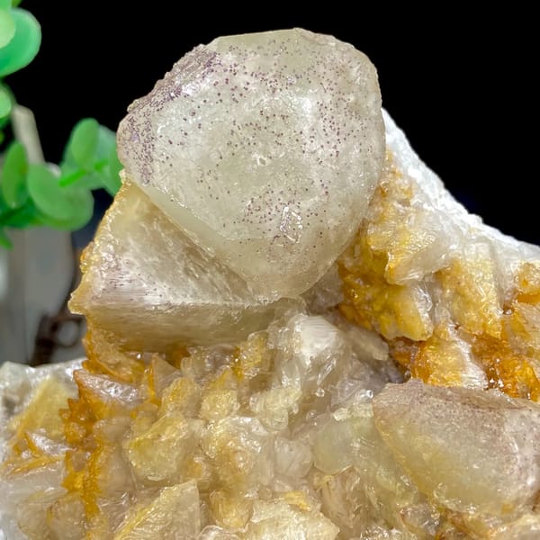 Pale calcite rhombs with yttrian fluorite on golden quartz from Guizhou, China, top view