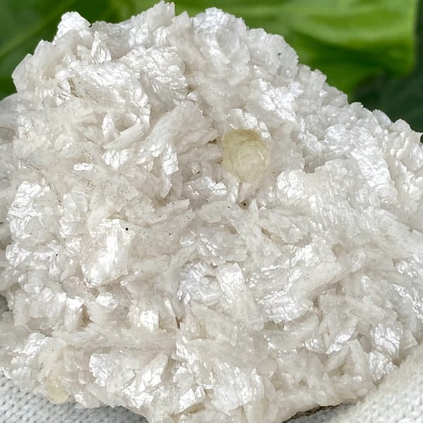 White dolomite plate with small pale calcite crystal from Guizhou, China, detail of the matrix contact