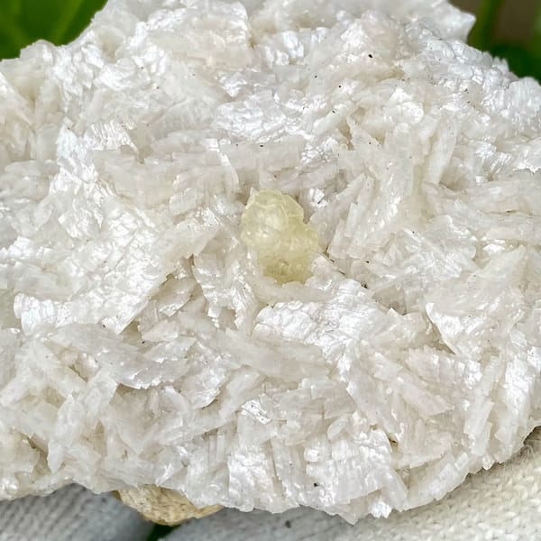 White dolomite plate with small pale calcite crystal from Guizhou, China, side view