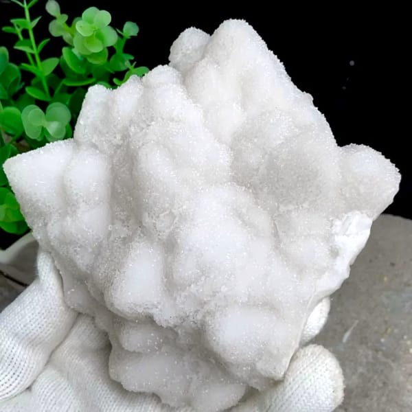 Snow-white sparkling quartz plate from Guangdong, China, held in gloved hand