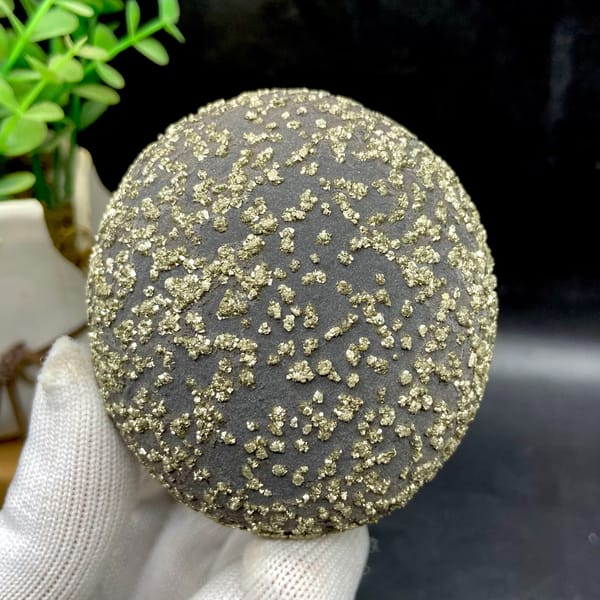 Dark iron concretion ball speckled with pyrite grains from Yunnan, China, close-up of the crystal faces