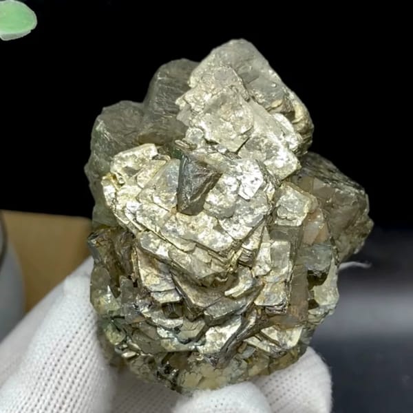 Stepped pyrite crystal stack with pale metallic sheen from Yunnan, China, held in gloved hand