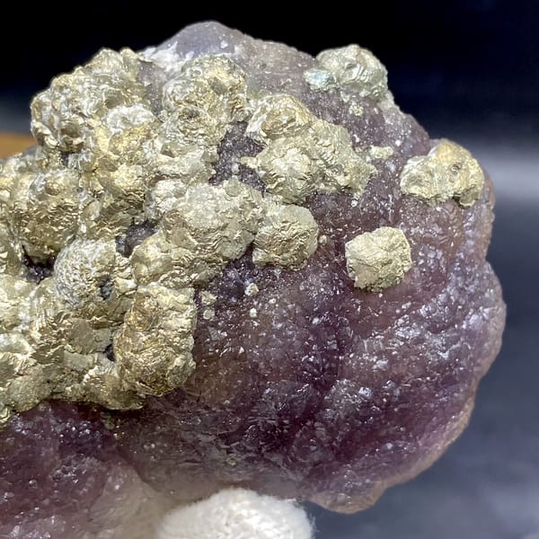 Pale pyrite rosettes over plum-purple fluorite from Jiangxi, China, detail of the matrix contact