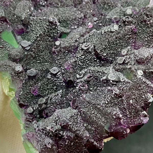 Plate of purple-edged green fluorite octahedra from Zhejiang, China, close-up of the crystal faces