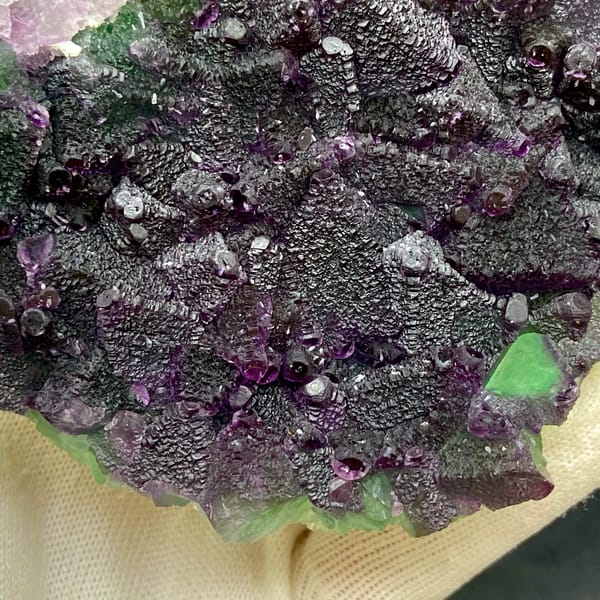 Plate of purple-edged green fluorite octahedra from Zhejiang, China, detail of the matrix contact