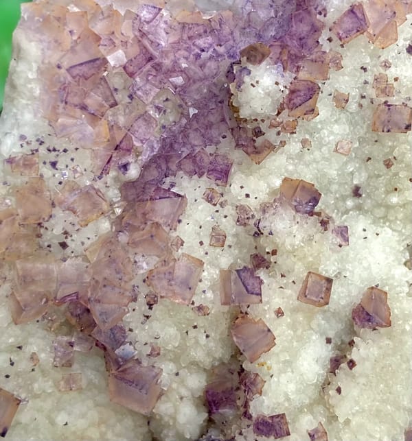 Purple fluorite cubes over white quartz plate from Guizhou, China, close-up of the crystal faces