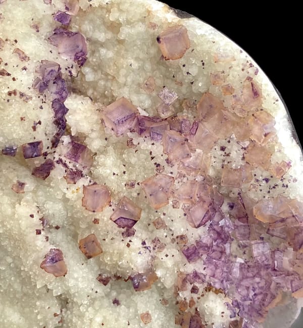 Purple fluorite cubes over white quartz plate from Guizhou, China, detail of the matrix contact
