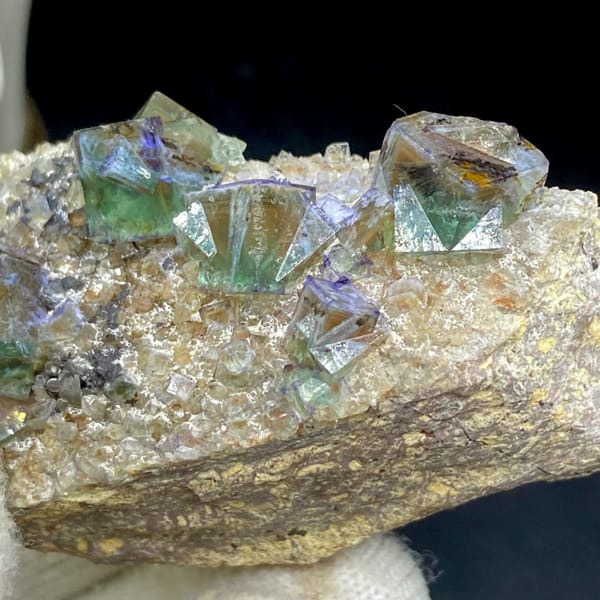 Green fluorite cubes with purple edges on grey matrix from Hebei, China, close-up of the crystal faces