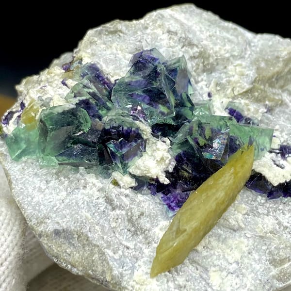 Purple-cored green fluorite cubes with yellow siderite blade from Inner Mongolia, China, detail of the matrix contact