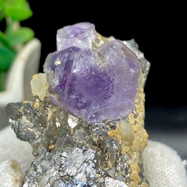 Purple fluorite cube on grey arsenopyrite and quartz from Yaogangxian, Hunan, China, close-up of the crystal faces