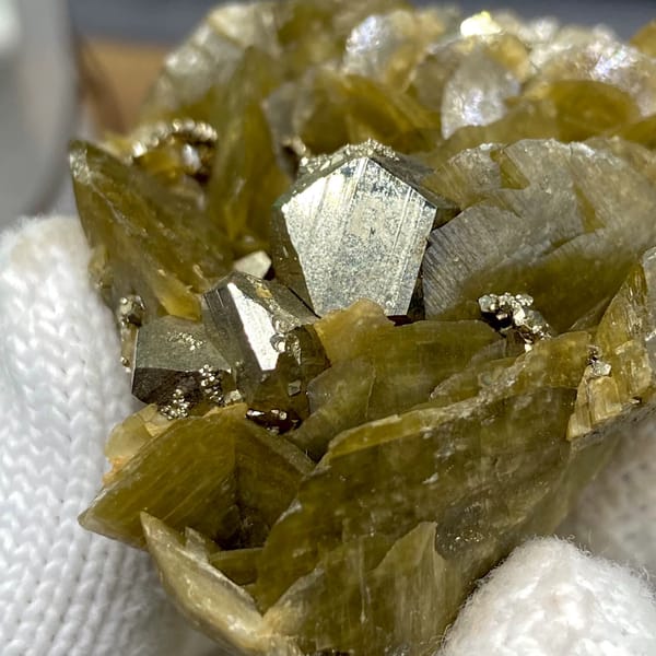 Olive siderite blades studded with bright pyrite dodecahedra from Guizhou, China, close-up of the crystal faces