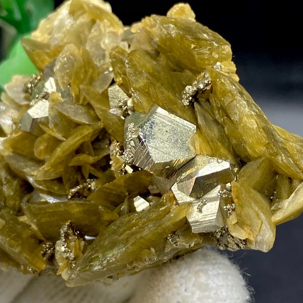 Olive siderite blades studded with bright pyrite dodecahedra from Guizhou, China, detail of the matrix contact