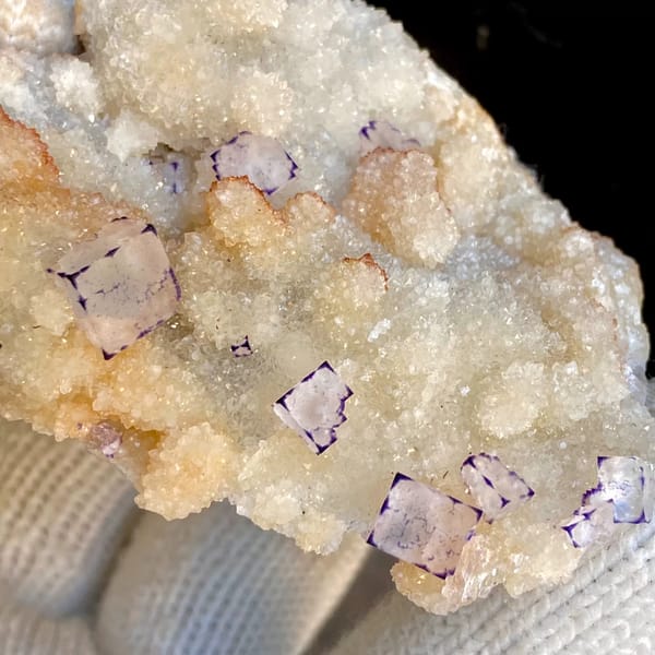 Small purple-edged fluorite cubes on white quartz druse from Guizhou, China, overall view