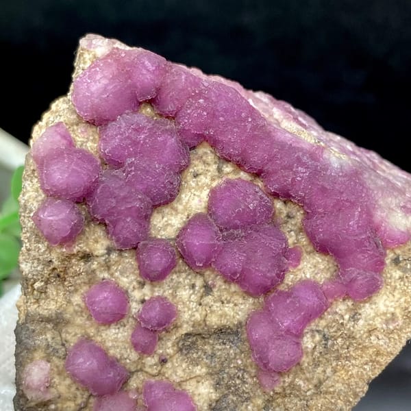 Purple-pink strawberry fluorite balls on sandy triangle from Henan, China, second angle