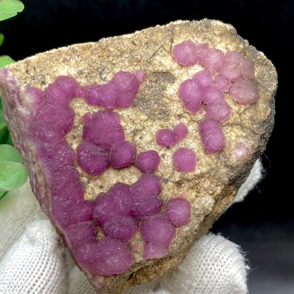 Purple-pink strawberry fluorite balls on sandy triangle from Henan, China, reverse side
