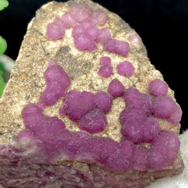 Purple-pink strawberry fluorite balls on sandy triangle from Henan, China, top view