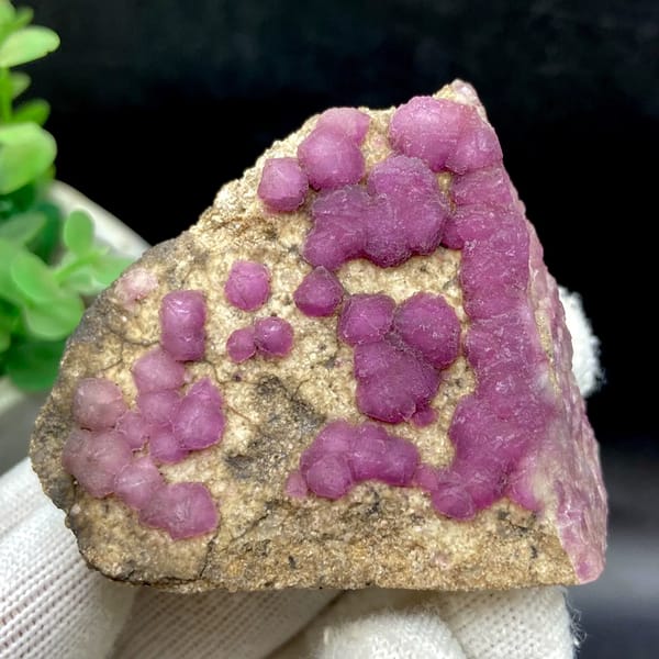 Purple-pink strawberry fluorite balls on sandy triangle from Henan, China, close-up of terminations