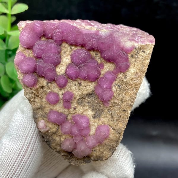 Purple-pink strawberry fluorite balls on sandy triangle from Henan, China, overall view