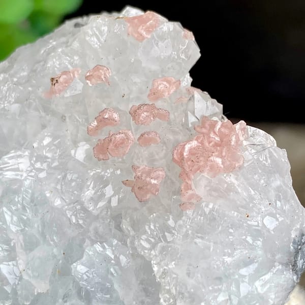 Pink rhodochrosite dots on white quartz block from Guangxi, China, close-up of the crystal faces