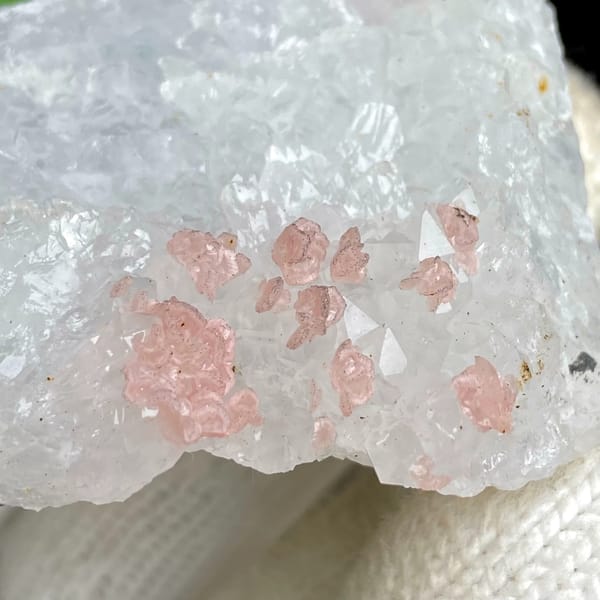 Pink rhodochrosite dots on white quartz block from Guangxi, China, detail of the matrix contact