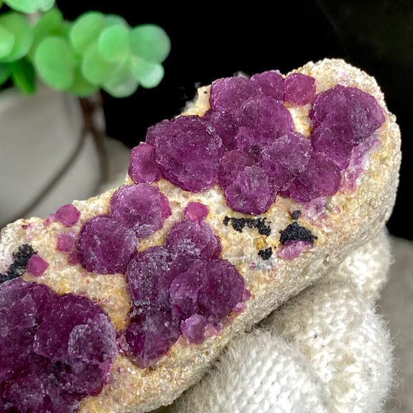 Raspberry strawberry-fluorite balls on tall tan sliver from Henan, China, second angle